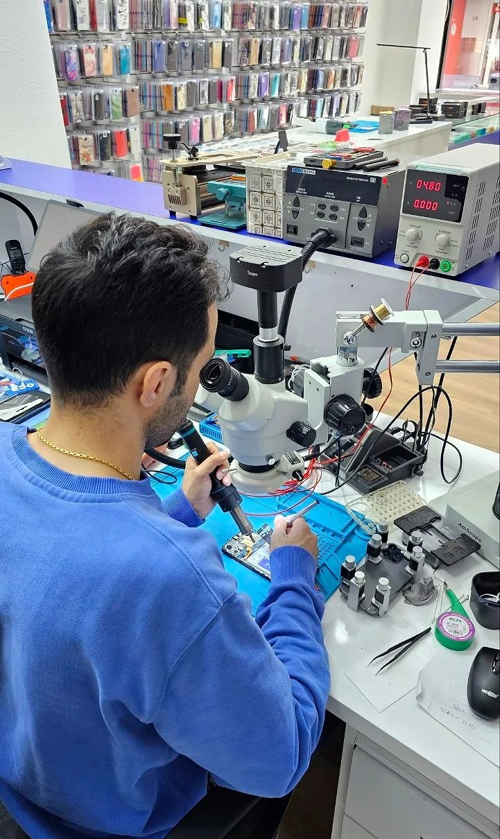 Reparaturplatz mit Mikroskop, Messgerät und Werkzeug im Laden